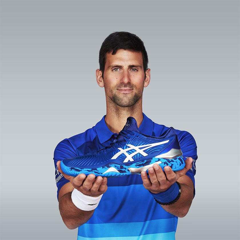 Novak Djokovic showing the blue tennis shoe developed with ASICS