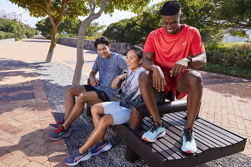 Three people sitting outside wearing running gear