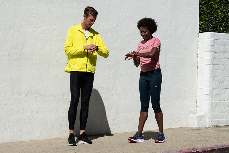 Two runners looking at their watches