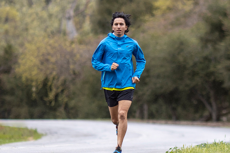Runner running outside in rain wearing a rain coat