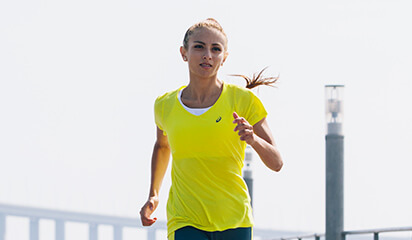 Woman running in ASICS apparel