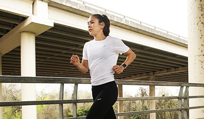 Woman running in ASICS apparel